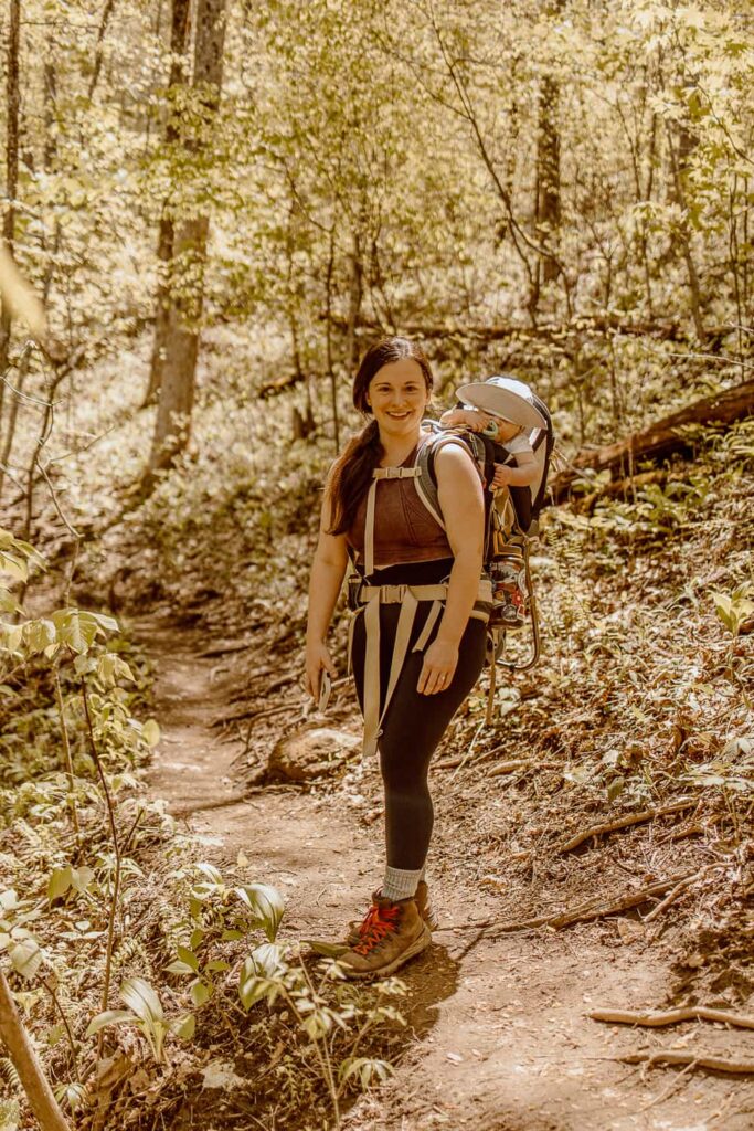 Woman with baby in hiking carrier on trail in Black Rock Mountain State Park.