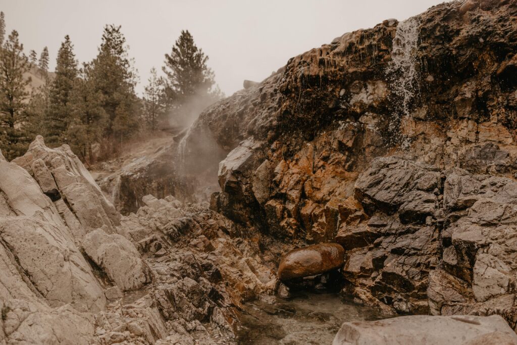 Landscape photo of hot spring waterfall over rocks in Idaho.