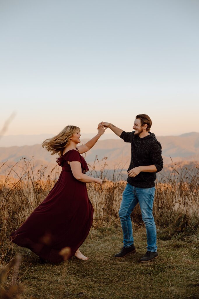 Man and woman dancing during sunset photoshoot at Max Patch Mountain in North Carolina.