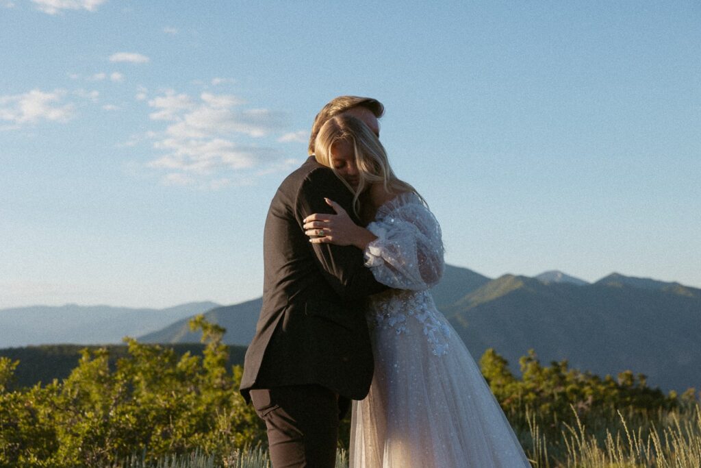 Man and woman hugging during their elopement in front of mountains.