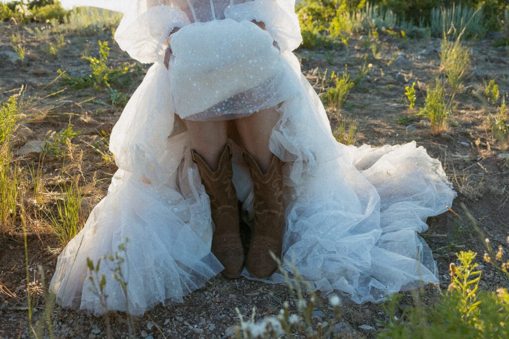 Woman in boots and wedding dress during elopement. 