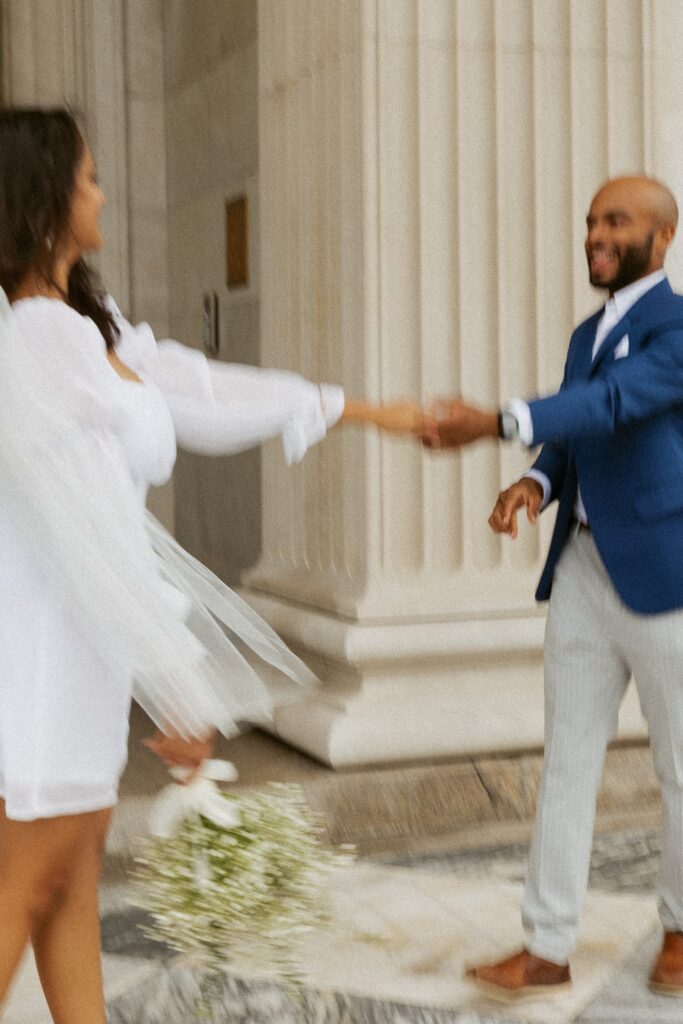 Man and woman dancing in wedding attire at courthouse in Charleston.
