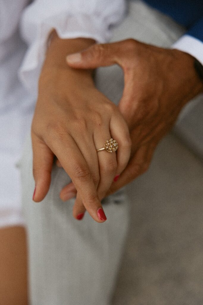 Close up of ring on womans hand while man holds her hand.