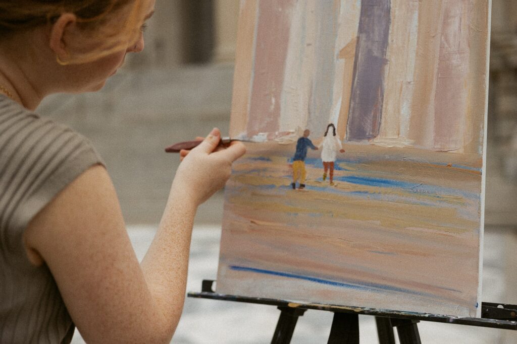 Woman painting a couple that is dressed in wedding attire. 