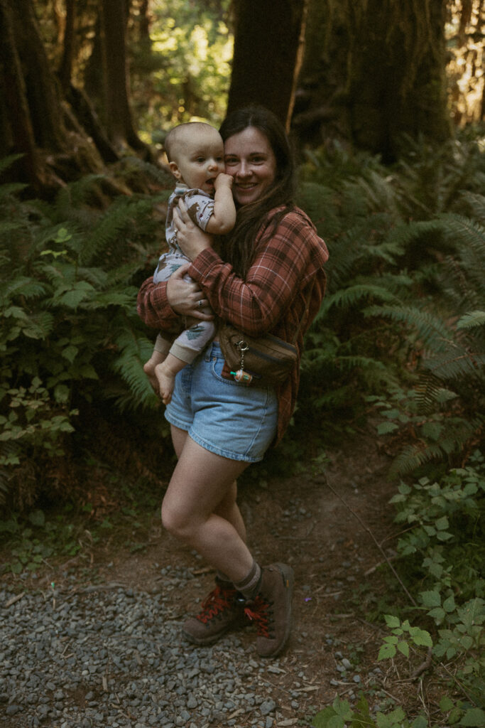 Woman holding baby in hoh rain forest.