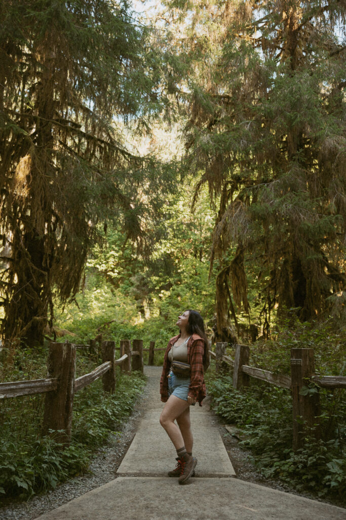 woman standing on trail in hoh rainforest.