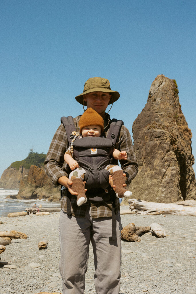 Man holding baby on ruby beach in washington. 