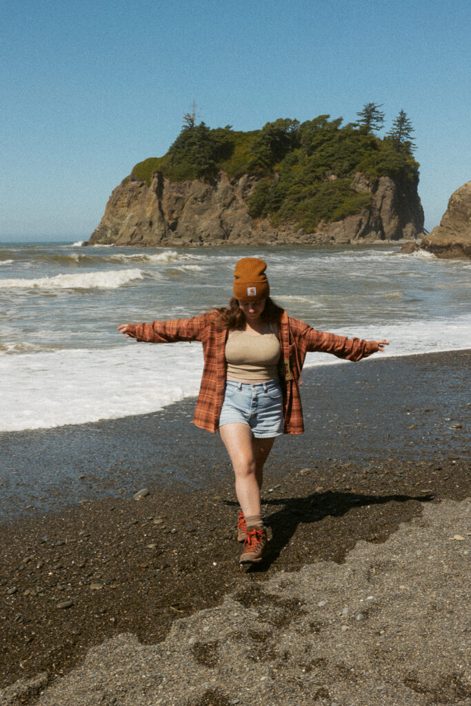 woman with arms out on ruby beach in washington.