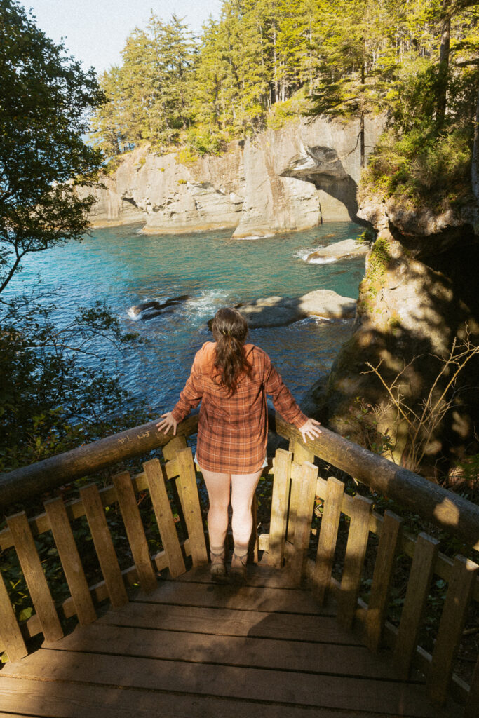 woman standing on platform on cape flattery trail. 