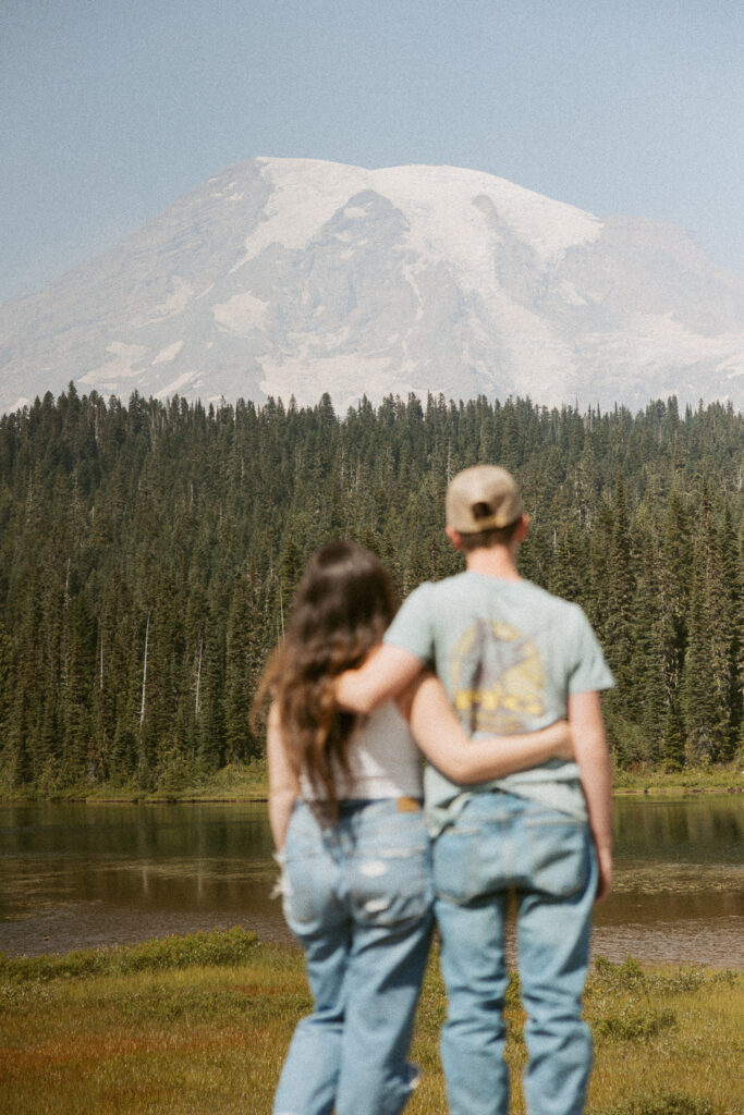 woman and kid standing in front of reflection lake looking at mt rainier.