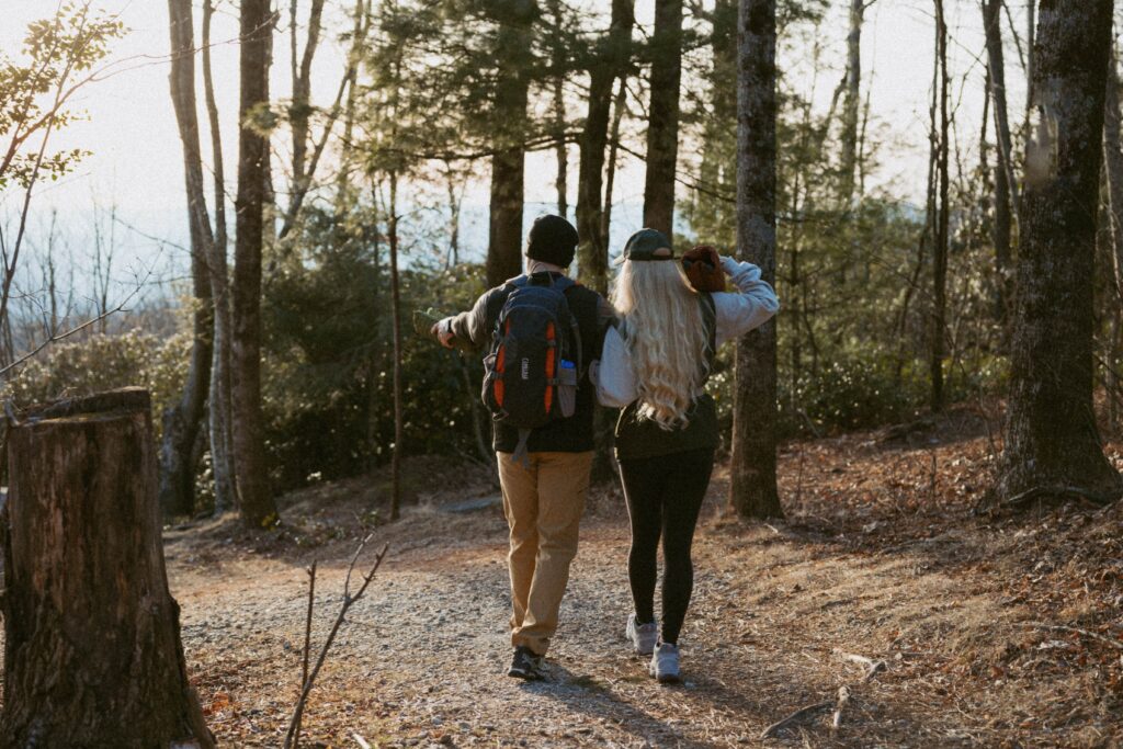 Man and woman walking down trail through woods at Sassafras Mountain.