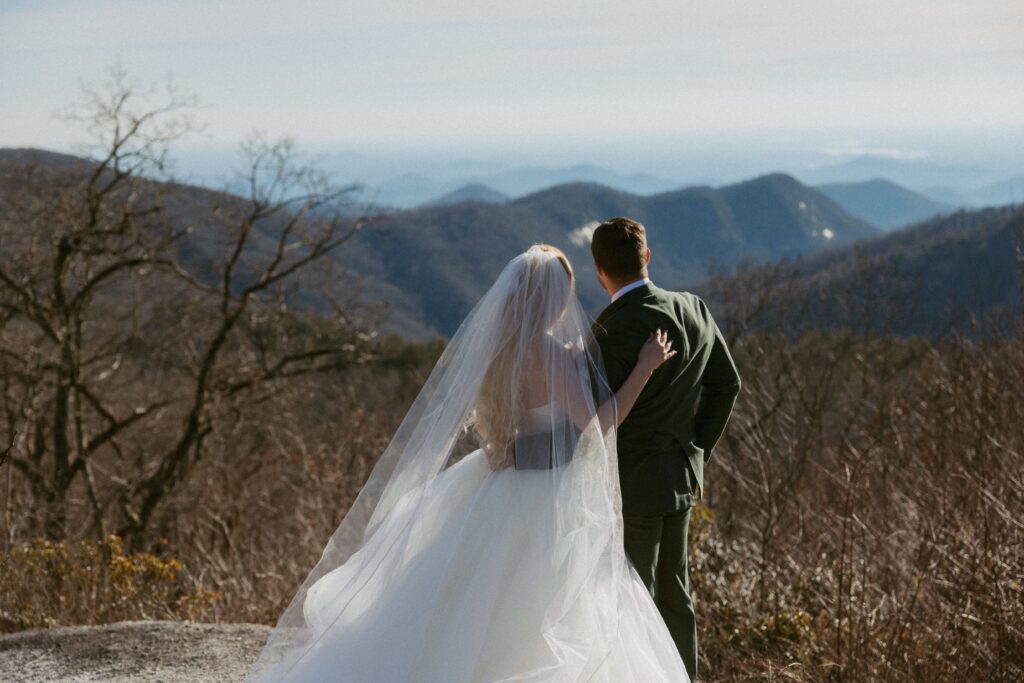 Man and woman looking at mountains at Sassafras Mountain during elopement.