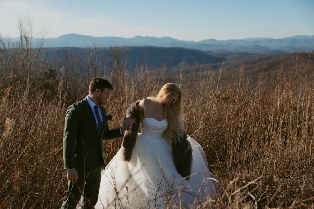 Man and woman walking down trail at Sassafras Mountain in wedding attire.
