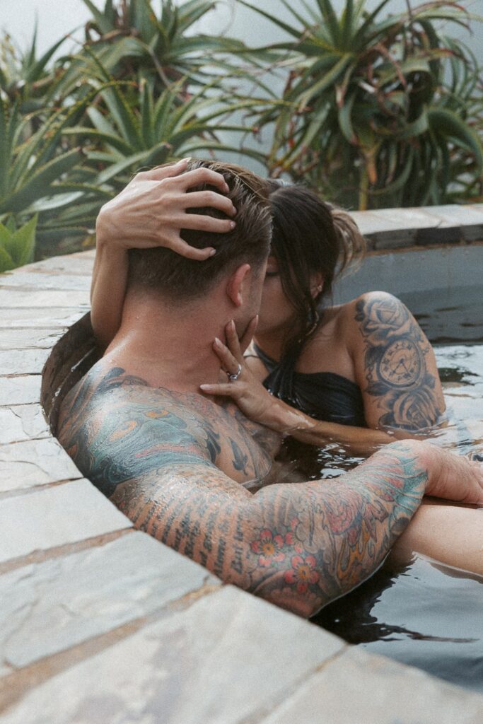 Man and woman kissing in a hot tub.