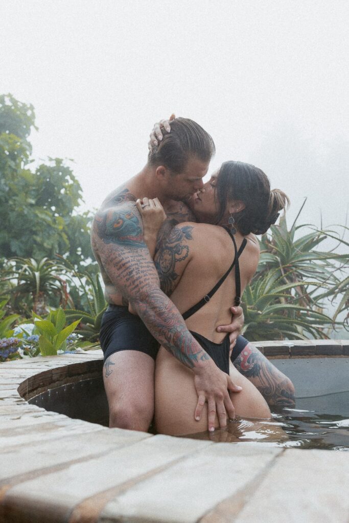 Man and woman hugging in a hot tub.