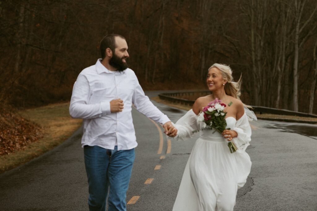 Man and woman running and smiling at each other while wearing wedding attire.