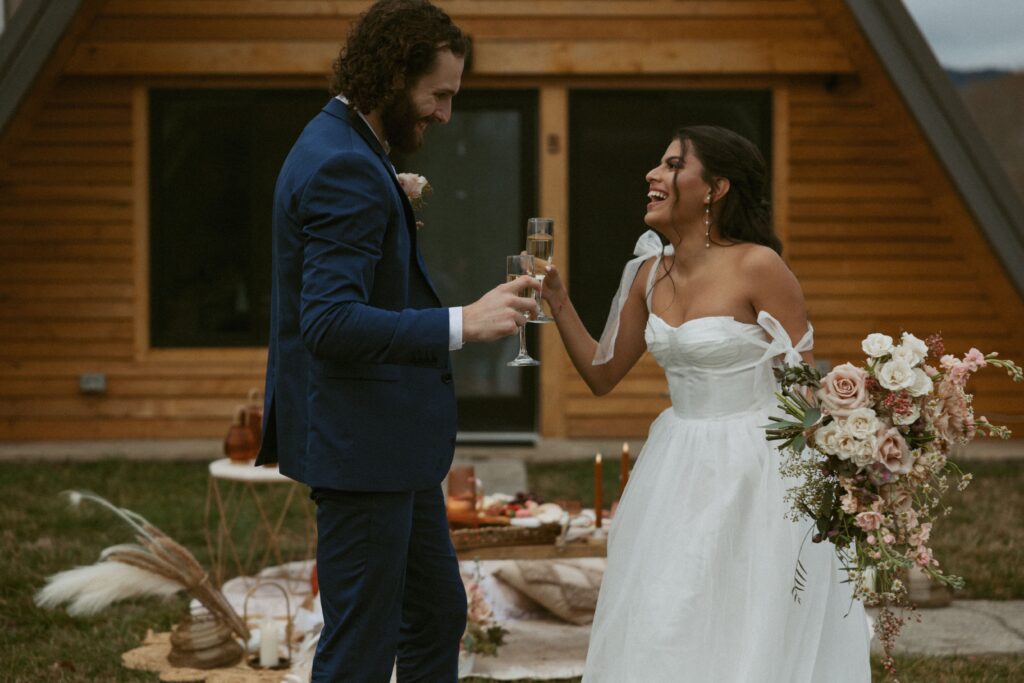 Man and woman with a glass of champagne during picnic at wedding reception.