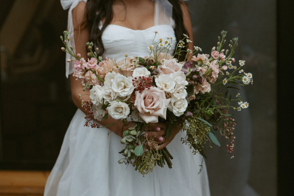Woman holding a pink and white wedding bouquet. 