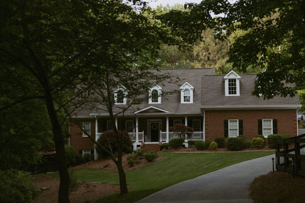 Brick house with trees in the foreground.