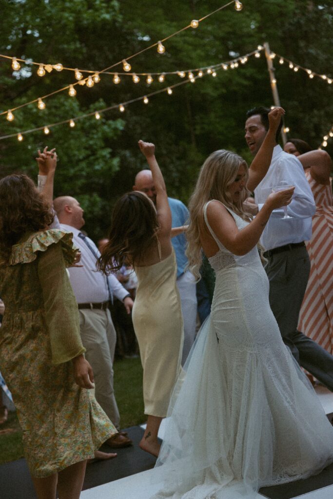 Group of people dancing at a backyard wedding. 