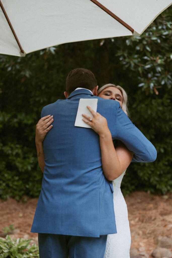 Man and woman hugging dressed in wedding attire.