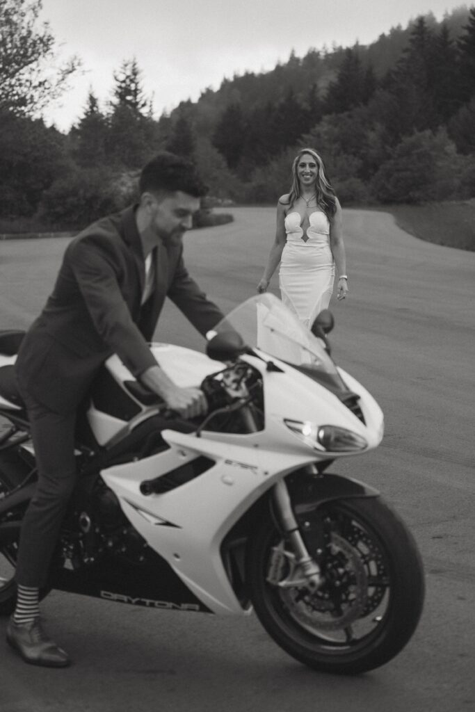 Woman smiling at man while he is on motorcycle.