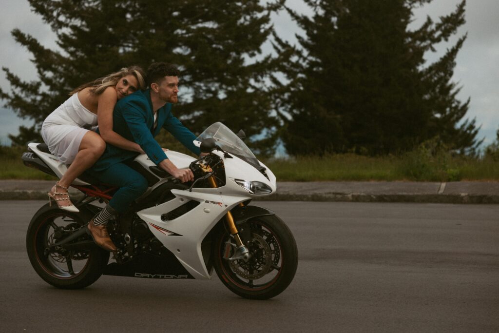 Woman hugging man while they ride a motorcycle.