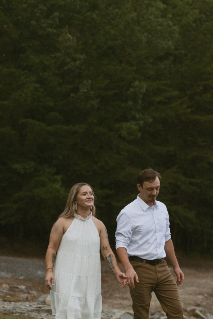 Man and woman walking, holding hands and smiling. 