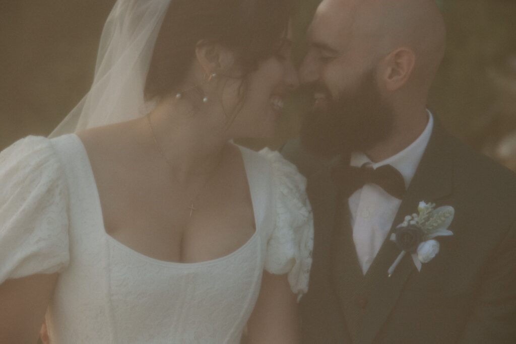 Close up of man and woman touching noses on their wedding day.