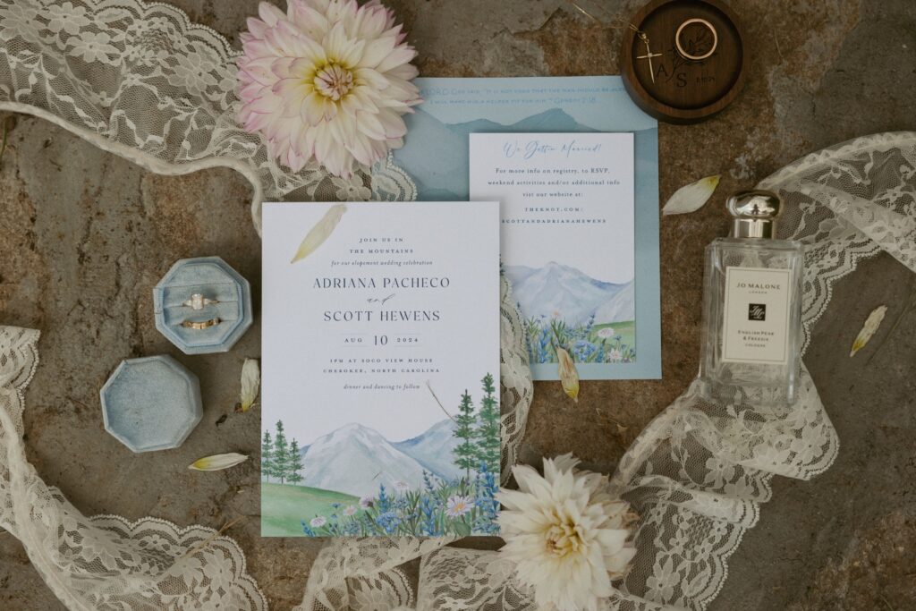 Detail shot of wedding invitation, wedding rings and flowers. 