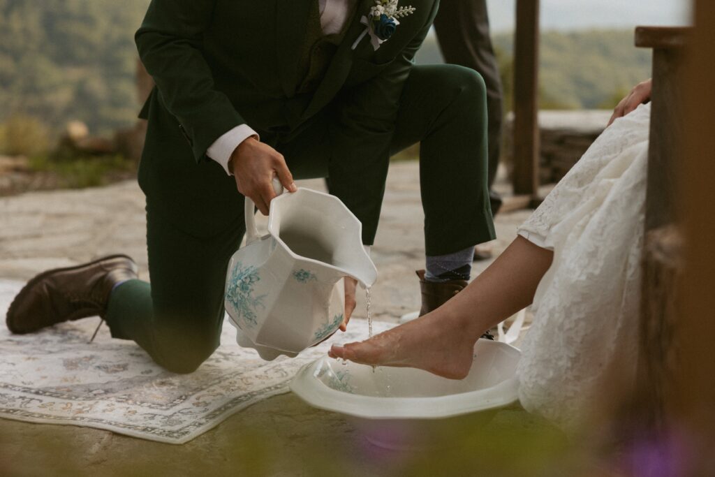 Man washing womans foot during a wedding foot washing ceremony. 