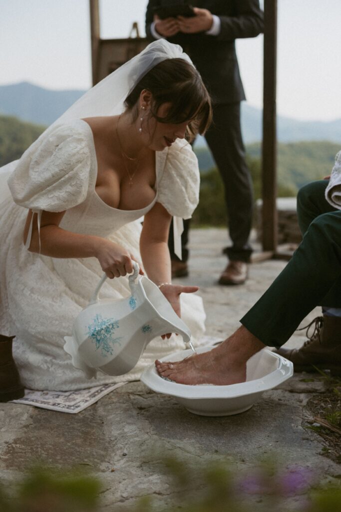 Woman washing mans foot during a wedding foot washing ceremony.