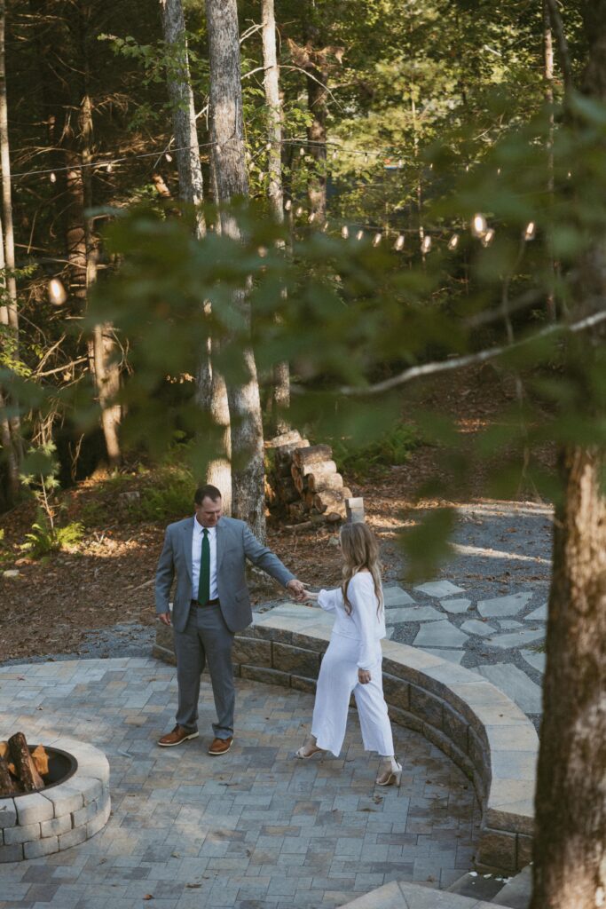 Man and woman dancing at fireplace of Airbnb.