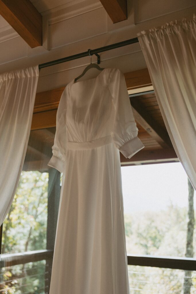 Wedding dress hanging in a door way.