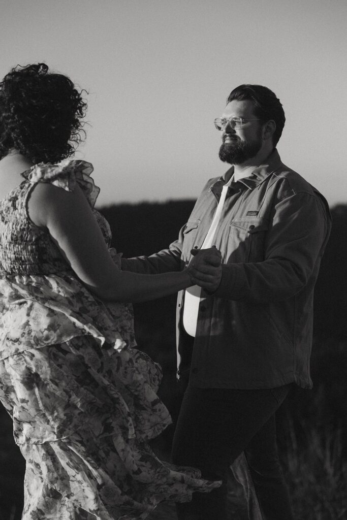 Man and woman holding hands and smiling at each other.