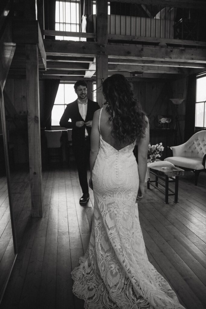 Man and woman standing in a cabin in wedding attire.