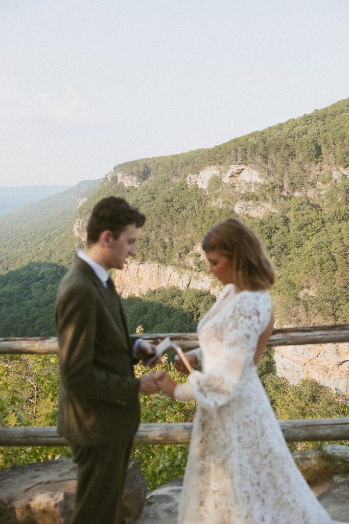 Man and woman in wedding attire reading vows at the main overlook in Cloudland Canyon State park.