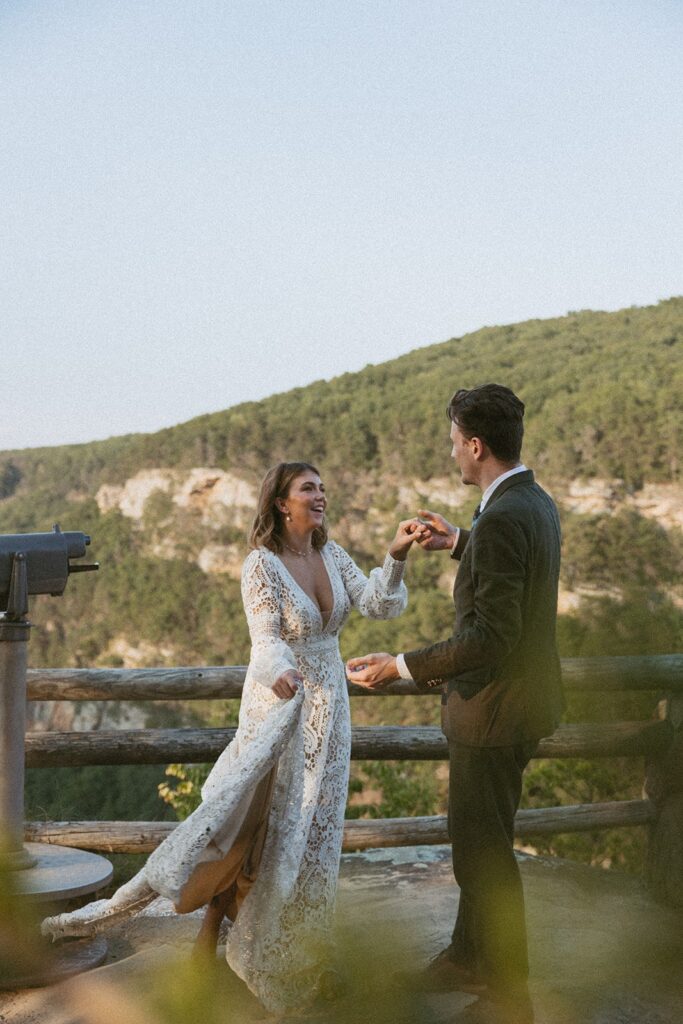 Man and woman in wedding attire dancing at the main overlook in Cloudland Canyon State park.