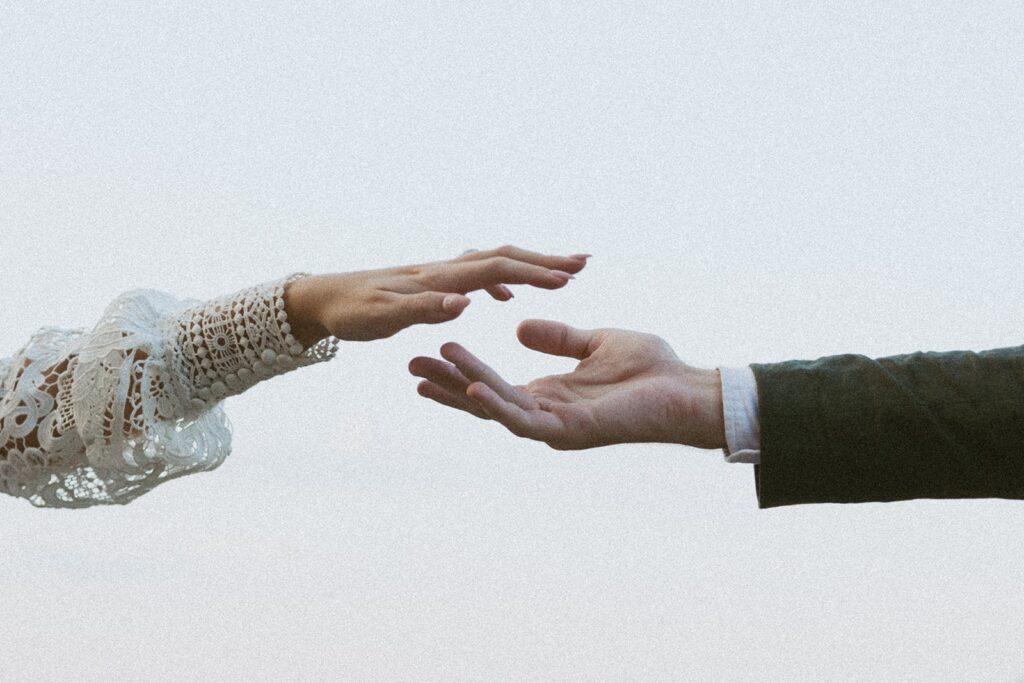 Man and woman in wedding attire going in to hold hands at the main overlook in Cloudland Canyon State park.