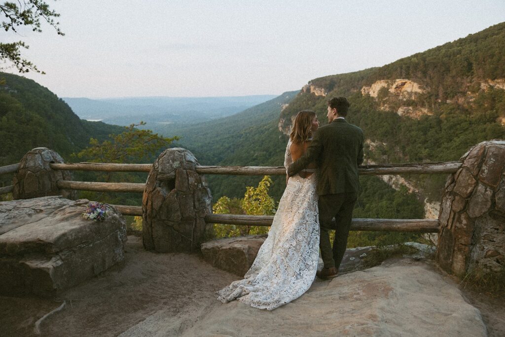 Man and woman in wedding attire standing at the main overlook in Cloudland Canyon State park.