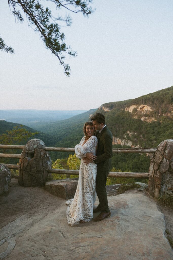 Man and woman in wedding attire dancing at the main overlook in Cloudland Canyon State park.