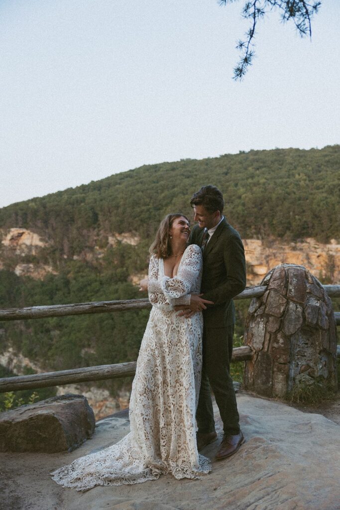 Man and woman in wedding attire dancing at the main overlook in Cloudland Canyon State park.