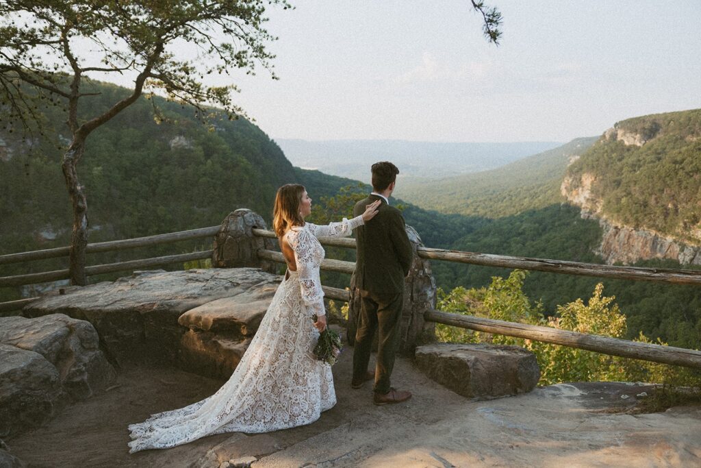 Man and woman in wedding attire standing at the main overlook in Cloudland Canyon State park.