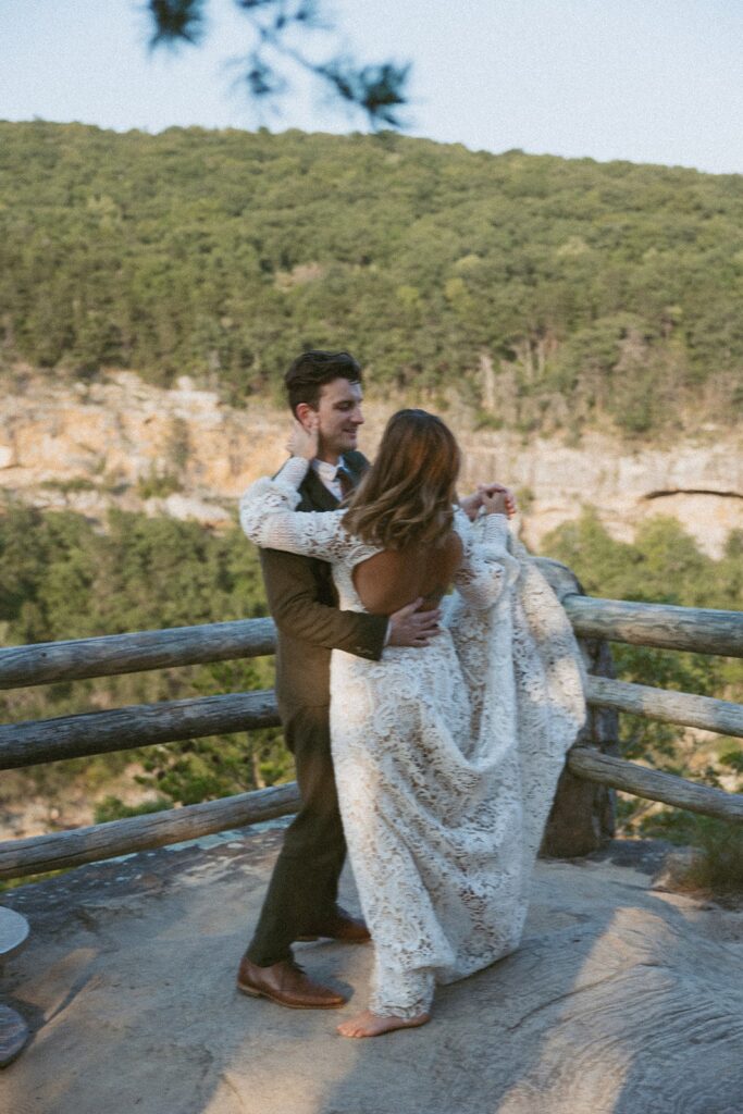 Man and woman in wedding attire dancing at the main overlook in Cloudland Canyon State park.