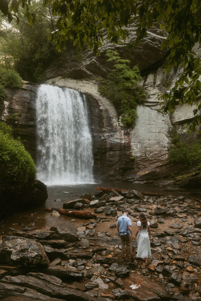 Man and woman standing in front of Looking Glass Falls.