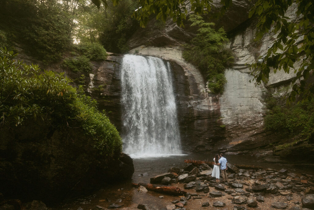 Man and woman standing in front of Looking Glass Falls.