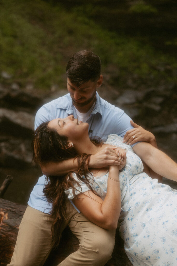 Man and woman smiling at each other in front of Looking Glass Falls.