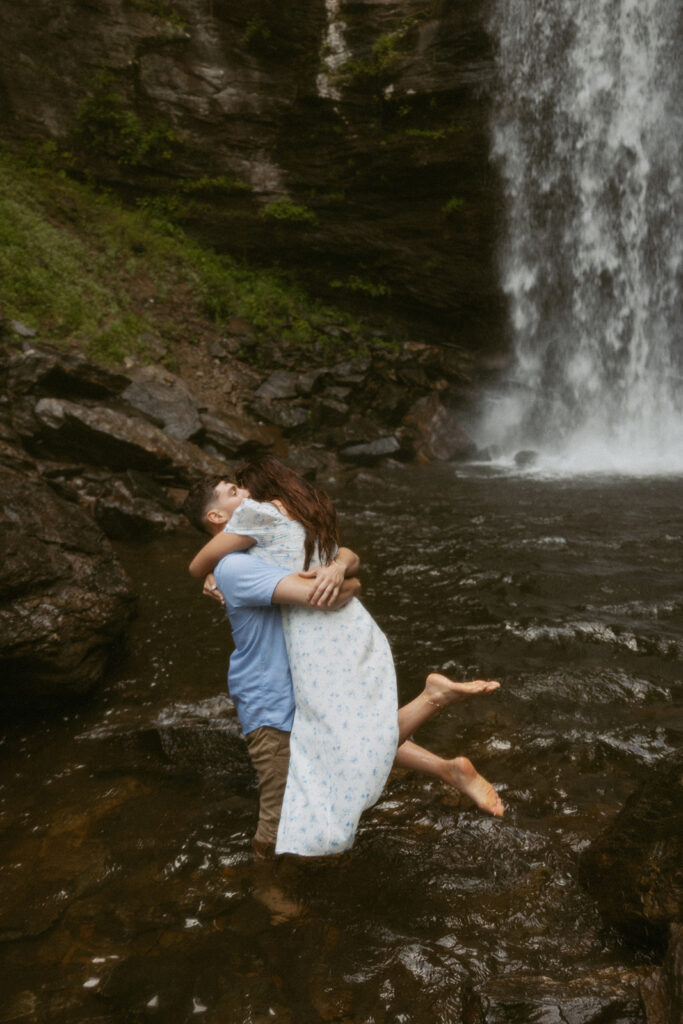 Man holding woman in front of Looking Glass Falls.