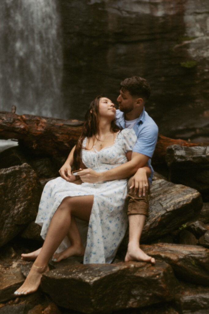 Man and woman sitting in front of Looking Glass Falls.