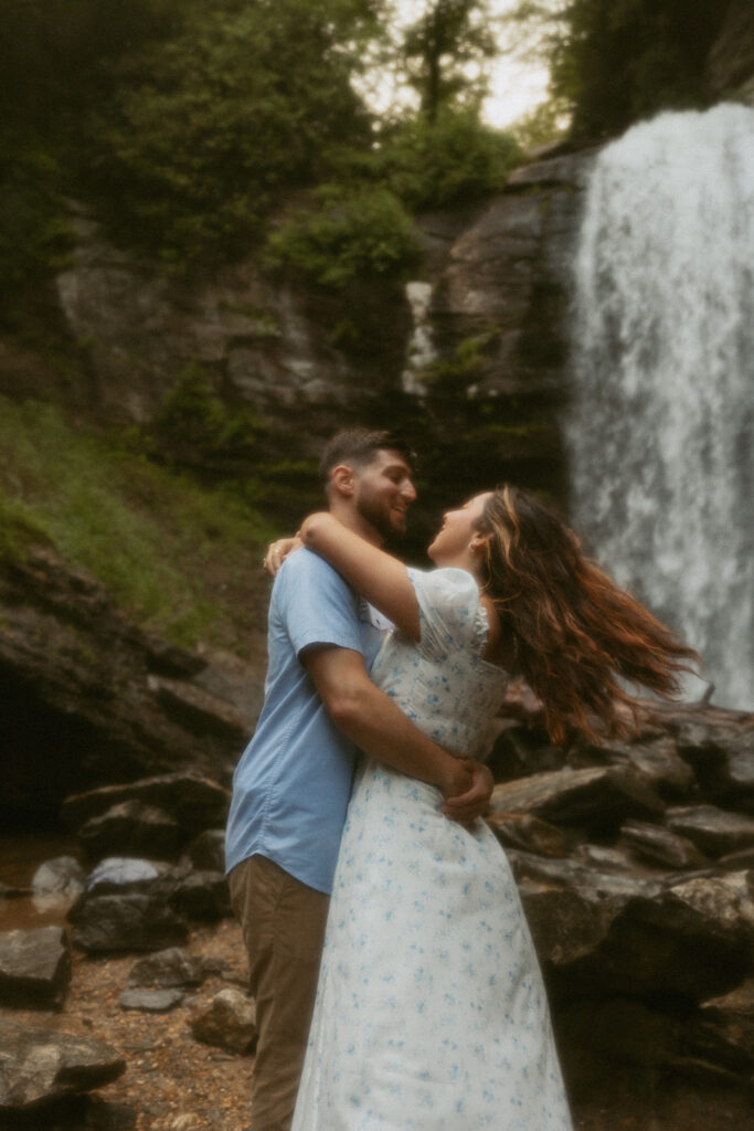 Man spinning woman in front of Looking Glass Falls.